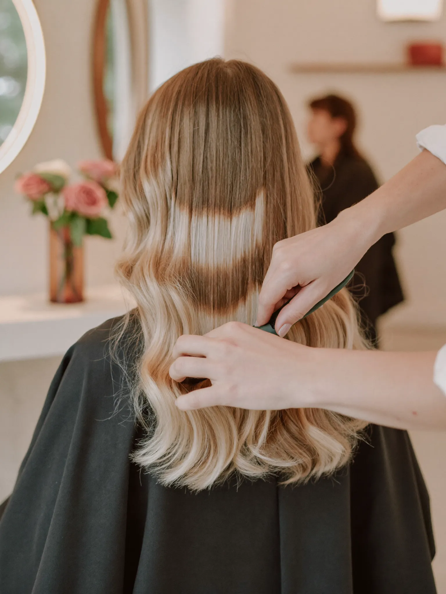 Colorist applying balayage highlights with foils