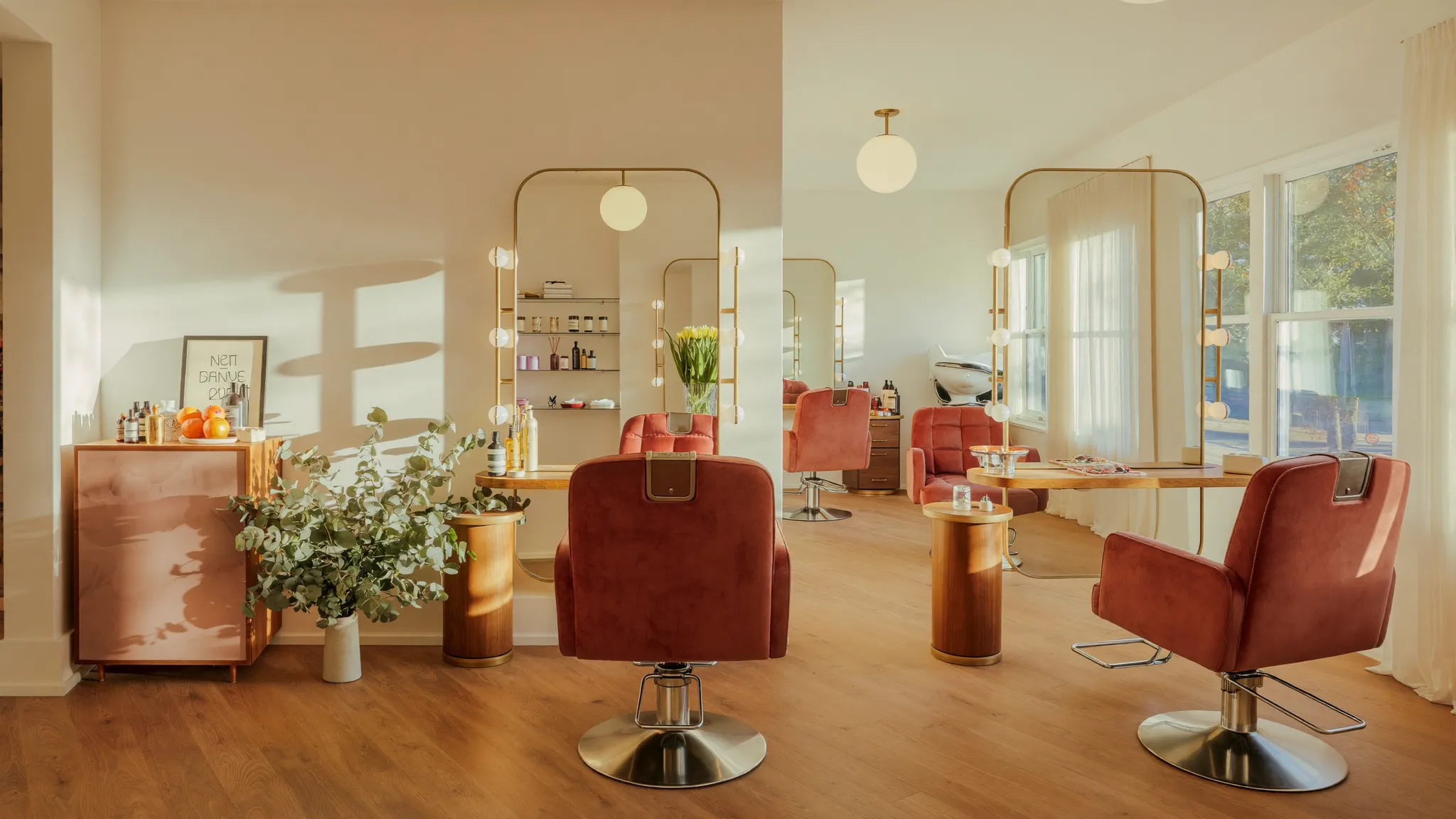 Inside Kate's Kuts salon — dusty rose styling chairs, brass mirrors and warm natural light